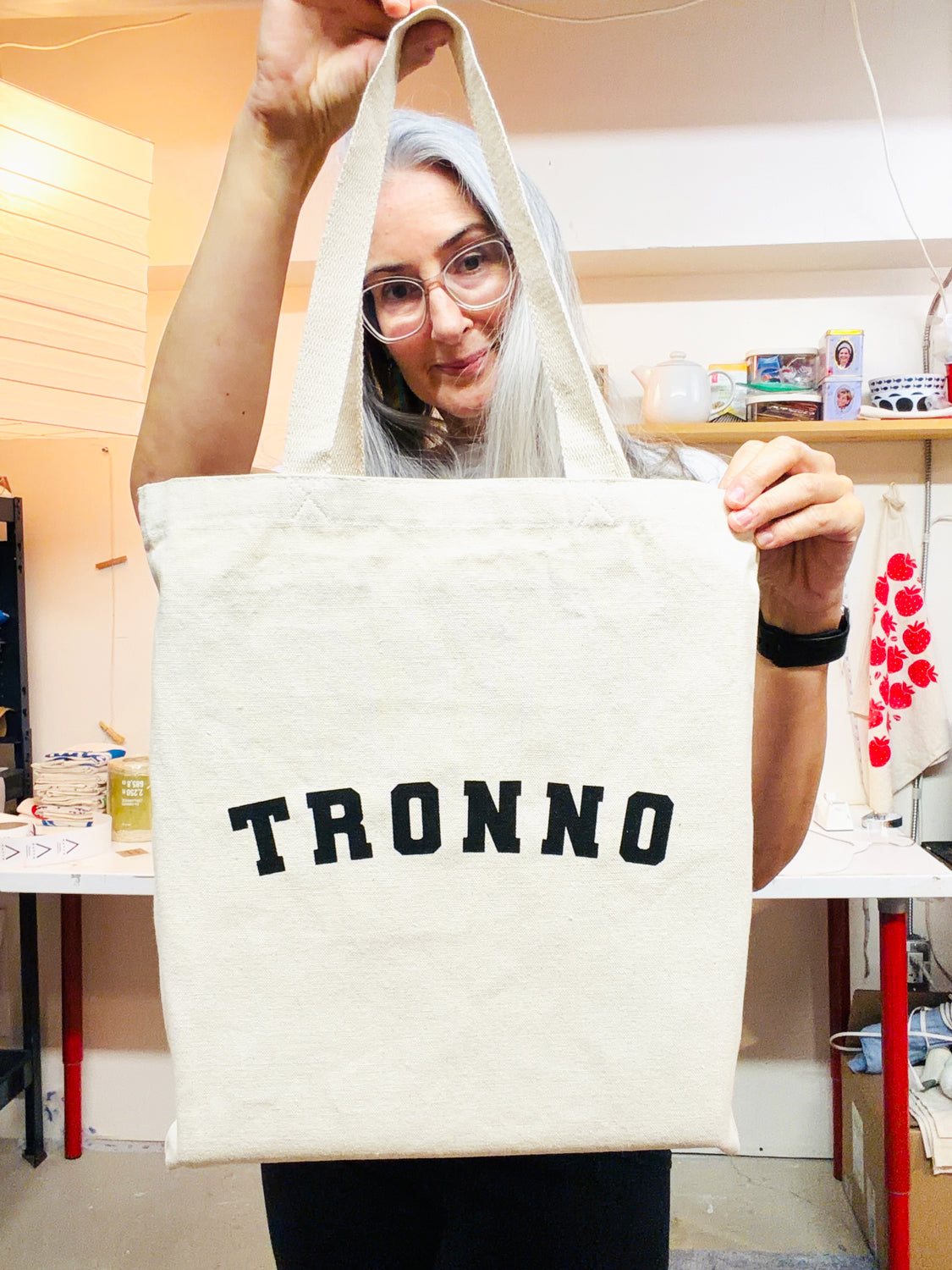 Paula of Havyn holding up her original designed TRONNO tote bag hand screen printed by her in Toronto Canada